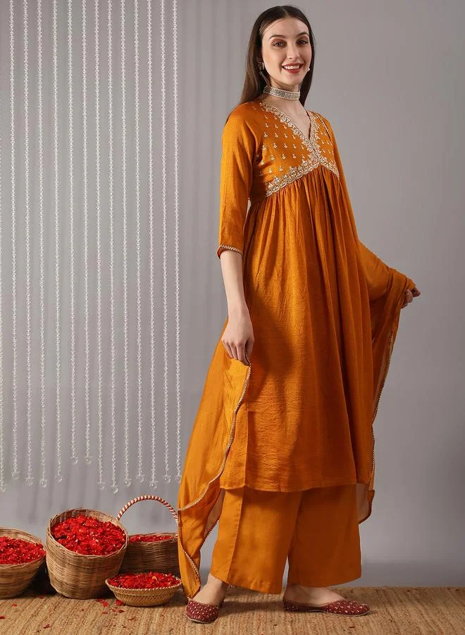 جلو باص مجموعة من كورتا خردلية بتفاصيل مطرزة مع بنطال ووشاح